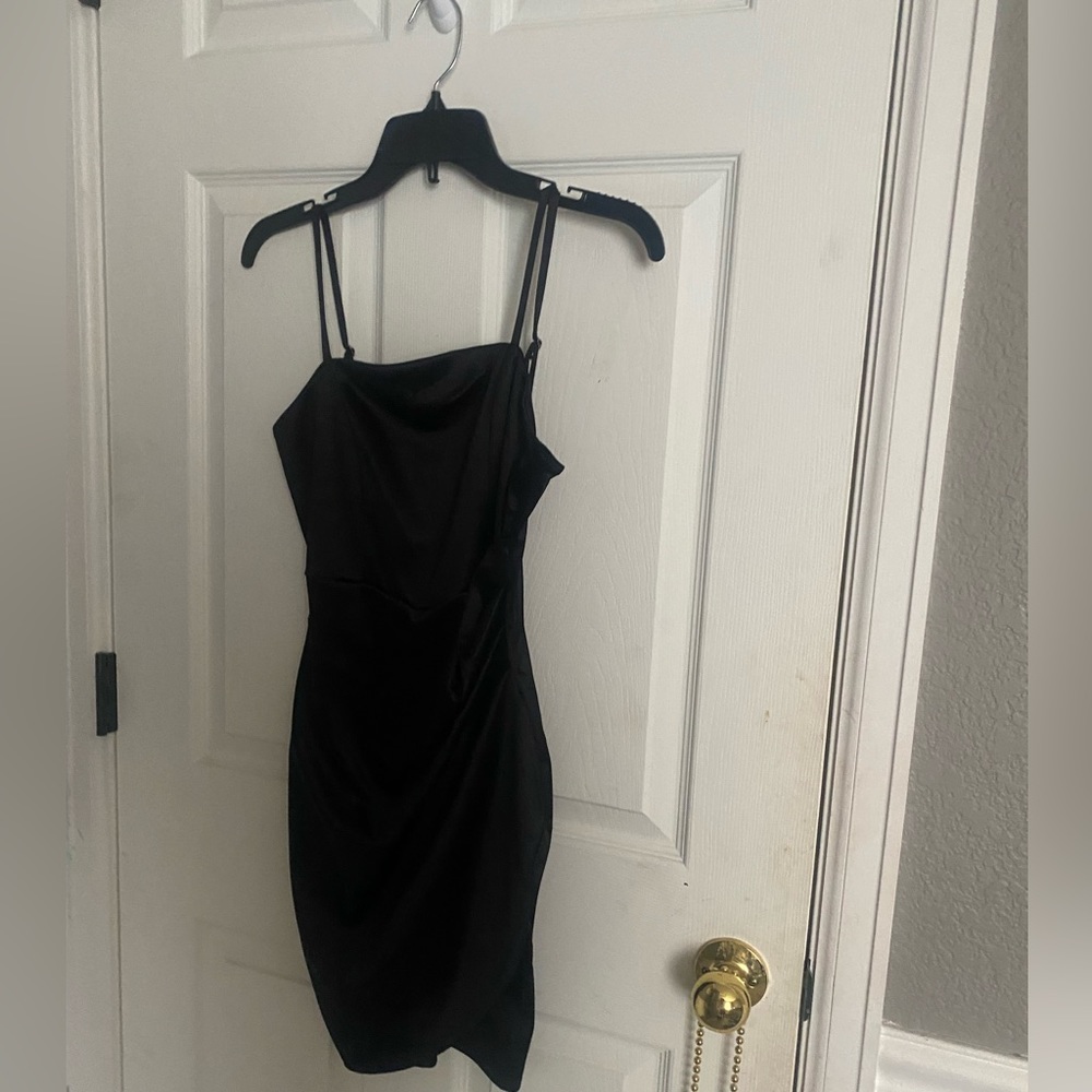 This is a short black satin dress in XS. This dress was made by honey and rose.
